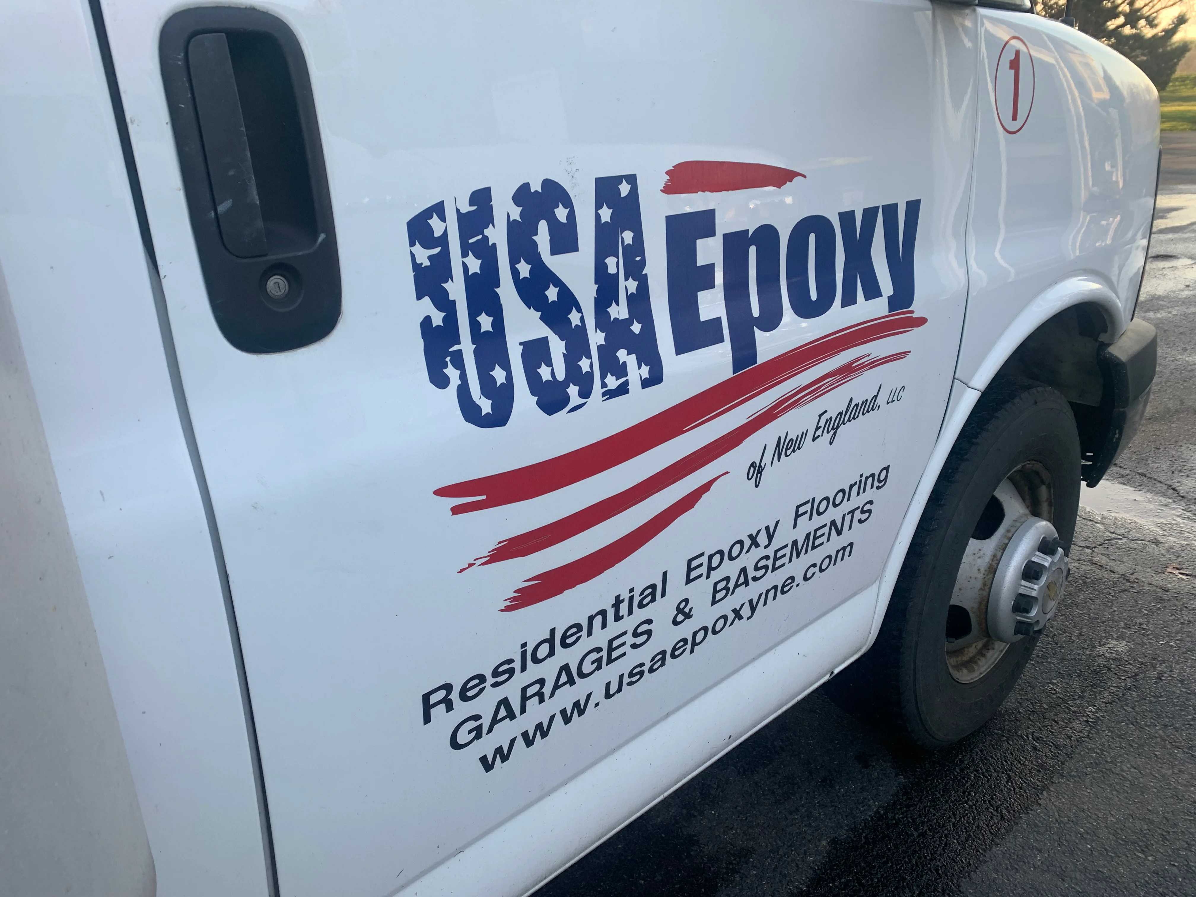 White service van with blue and red custom vinyl wrap featuring company logo and text