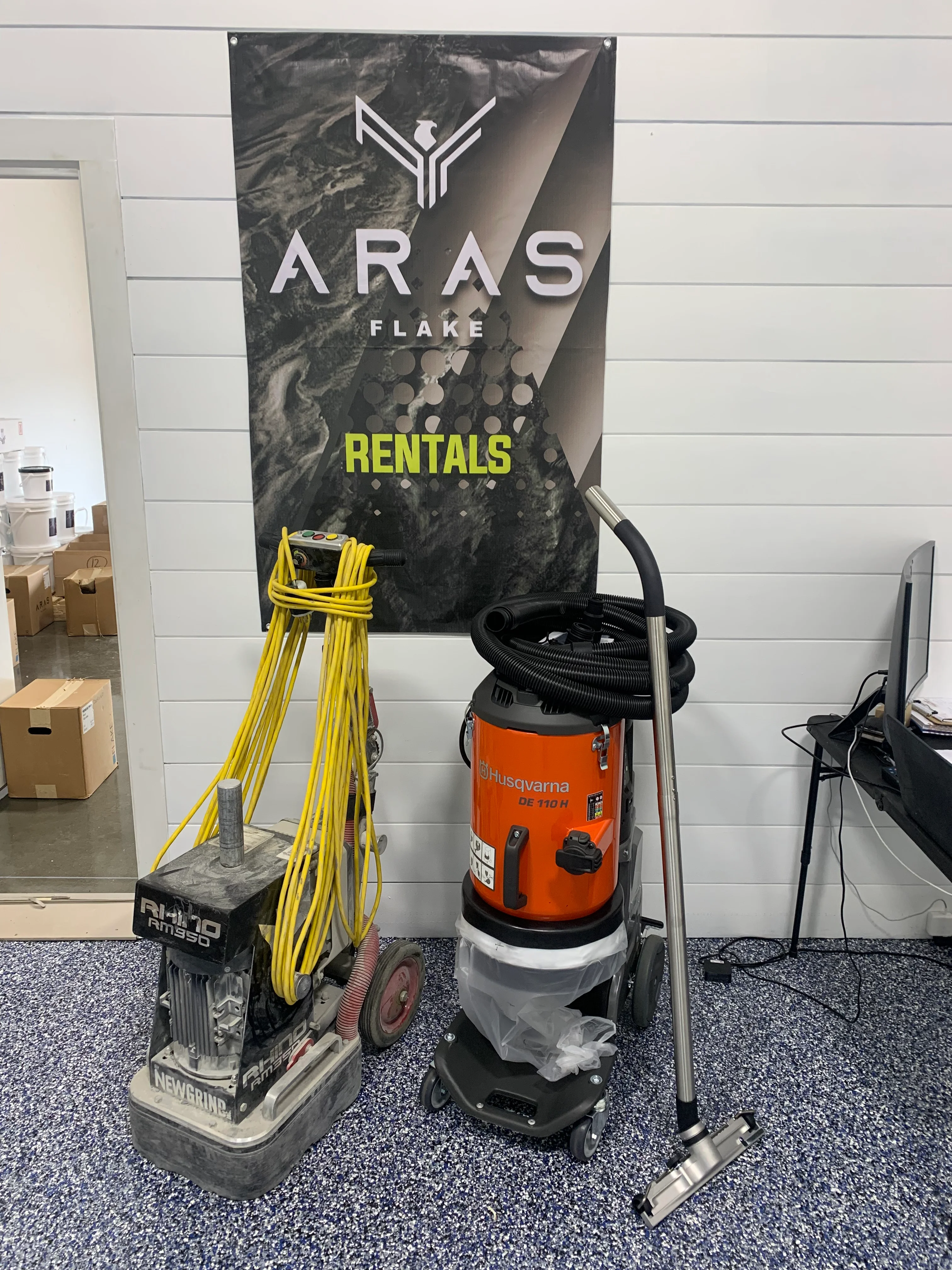 Concrete grinder and wet vacuum rental equipment with yellow cords and black hoses