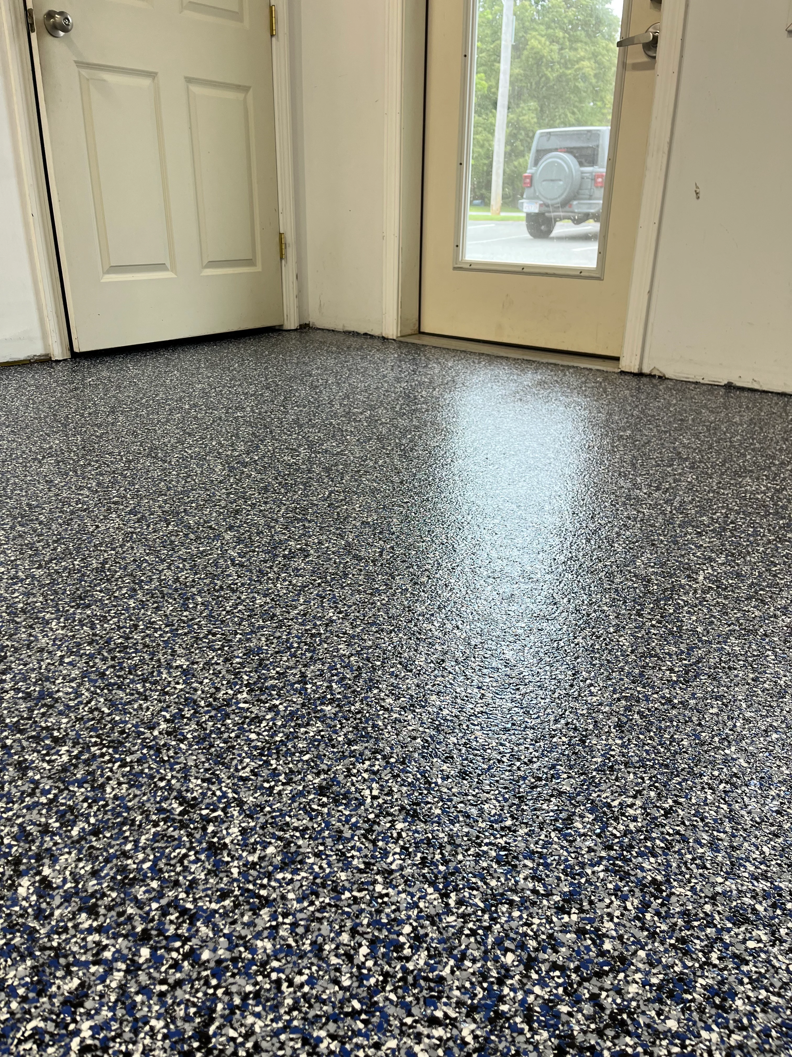 Epoxy garage floor with gray and white flake finish, glossy sealed surface