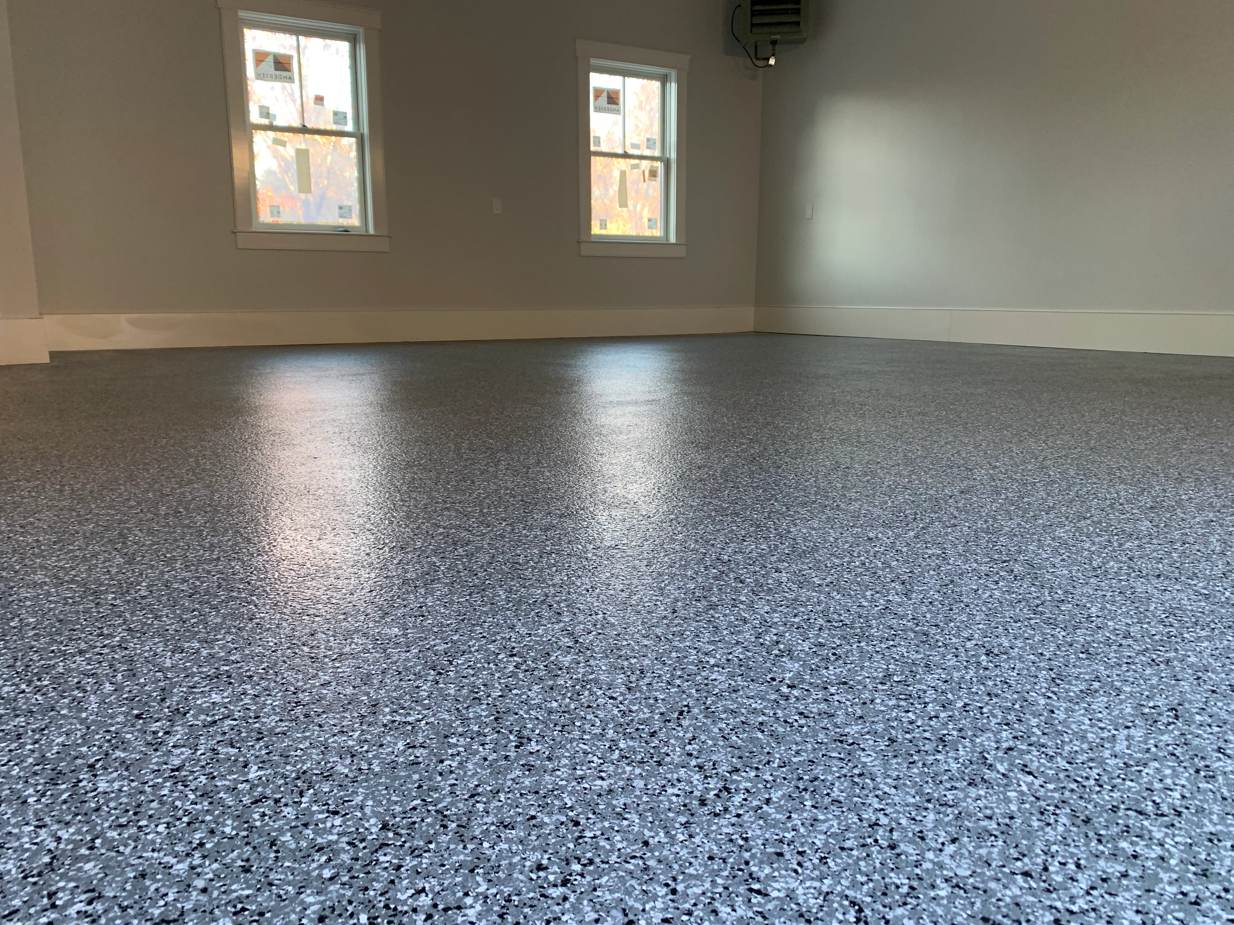 Polished gray epoxy floor with reflective finish in commercial space with windows