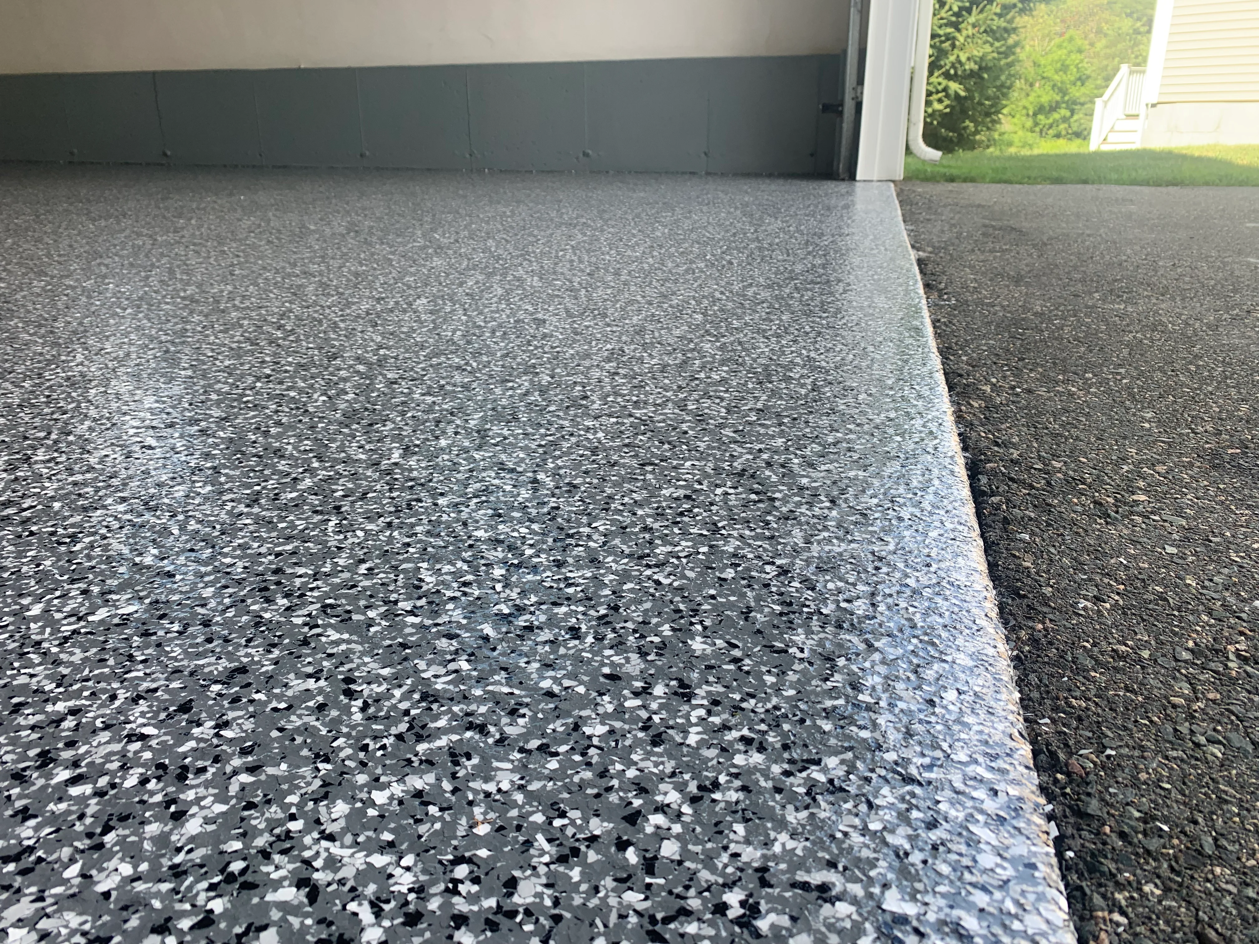 Epoxy flake garage floor with charcoal and white aggregate, clean edge detail
