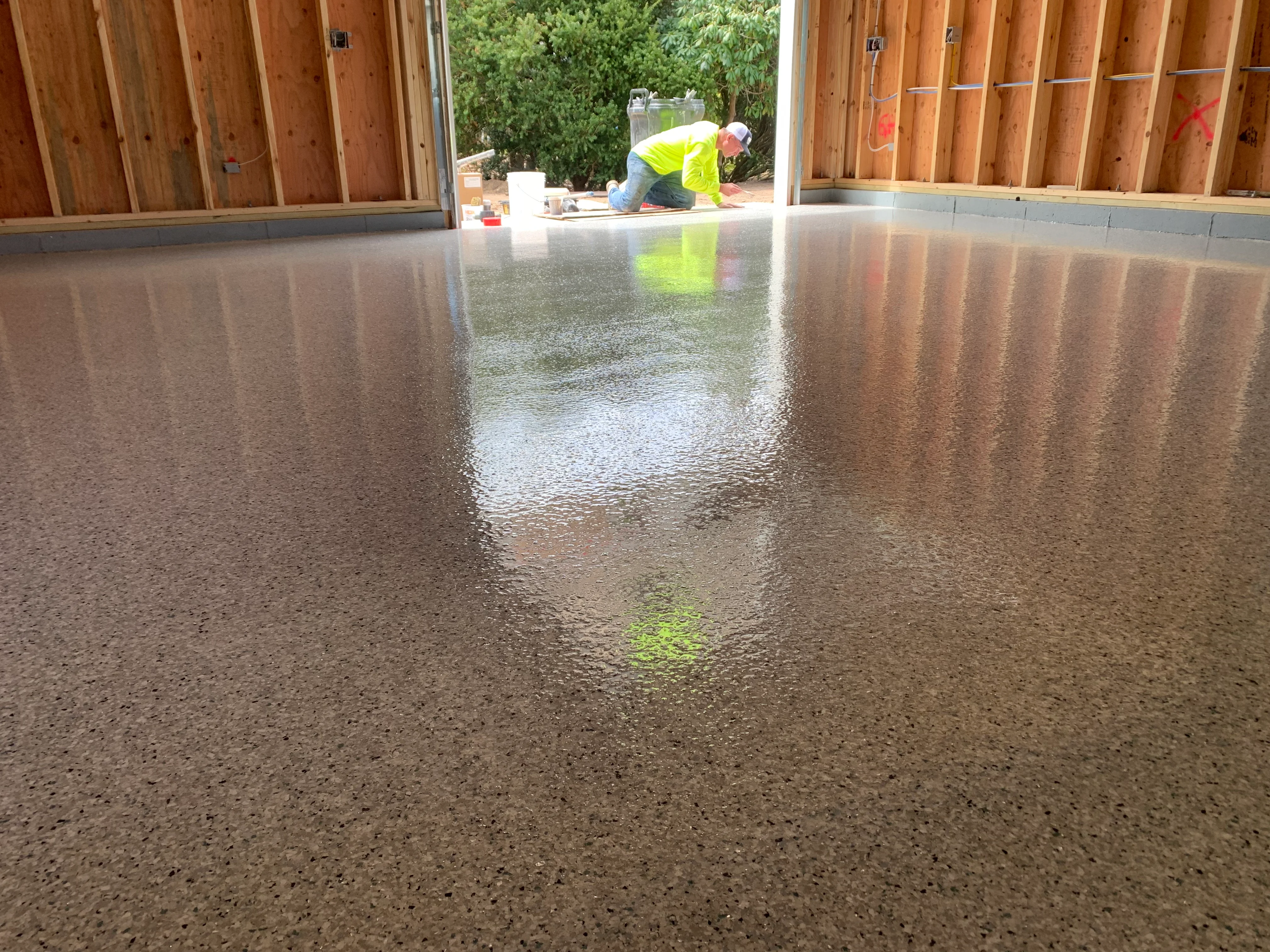 Polished epoxy garage floor with aggregate finish and high-gloss reflective surface