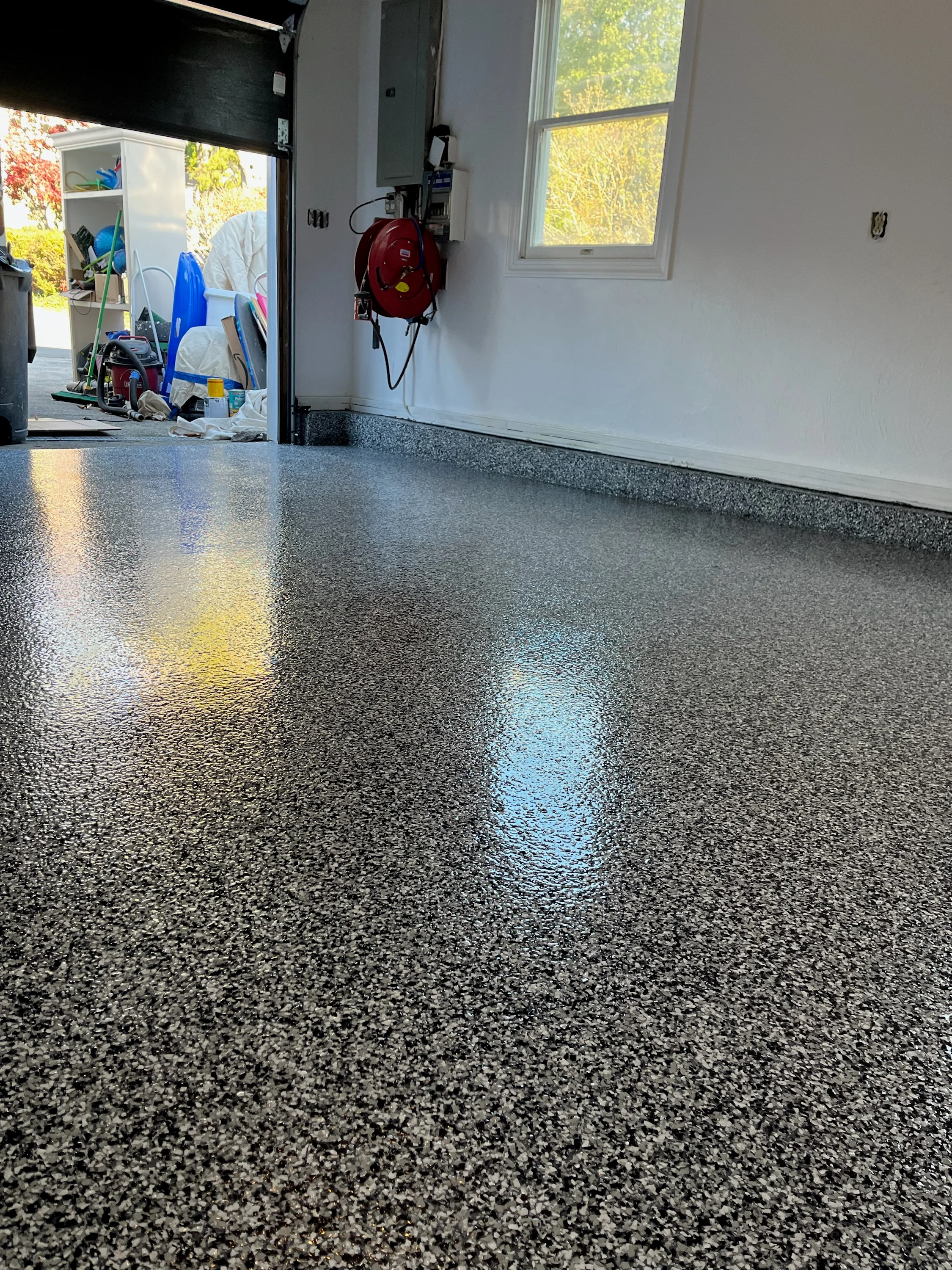 Gray epoxy garage floor with blue and yellow safety stripes, high-gloss finish