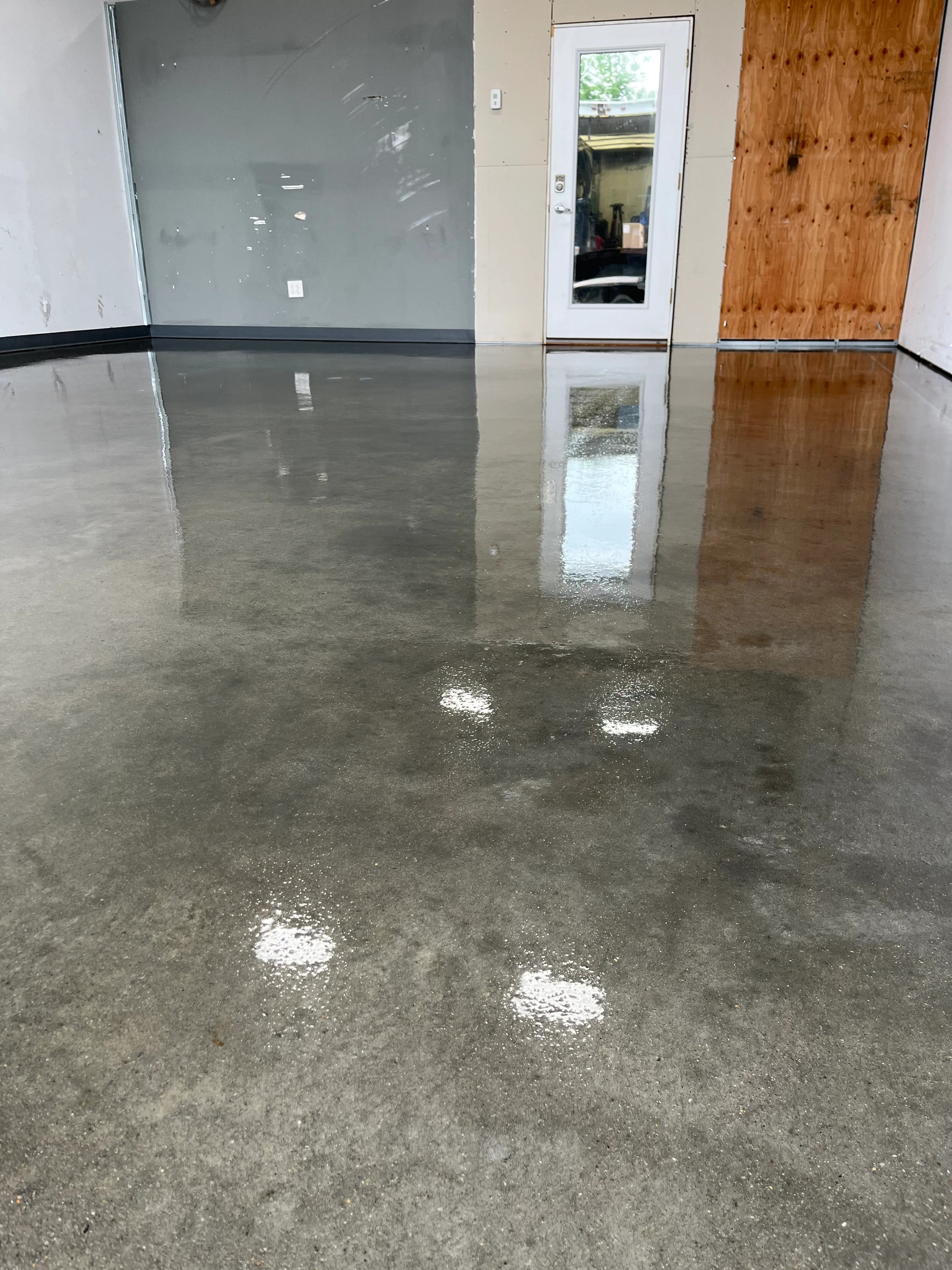 Polished concrete floor with glossy epoxy coating and black safety stripe