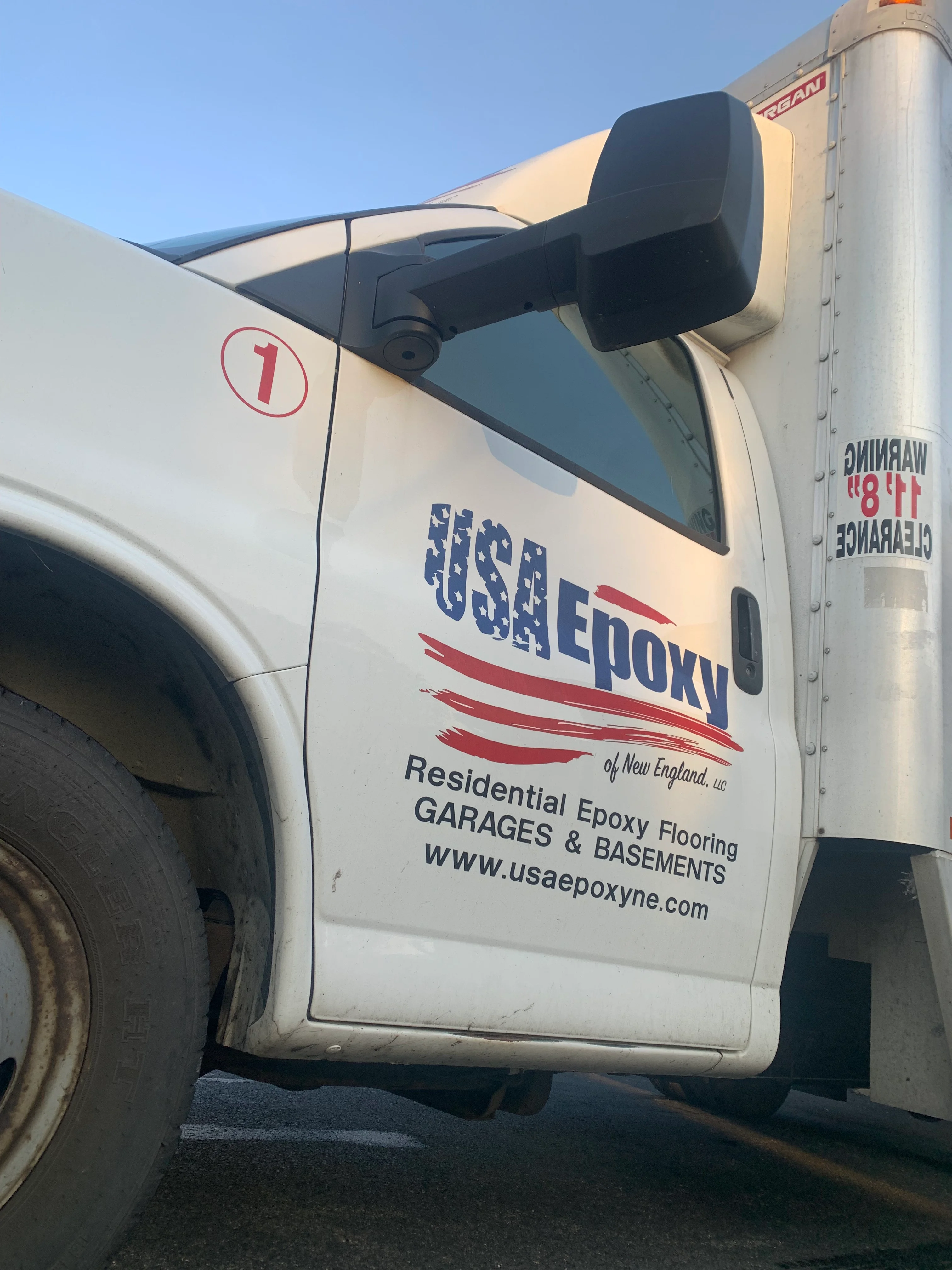 White service truck with custom vinyl wrap displaying company logo and epoxy flooring branding