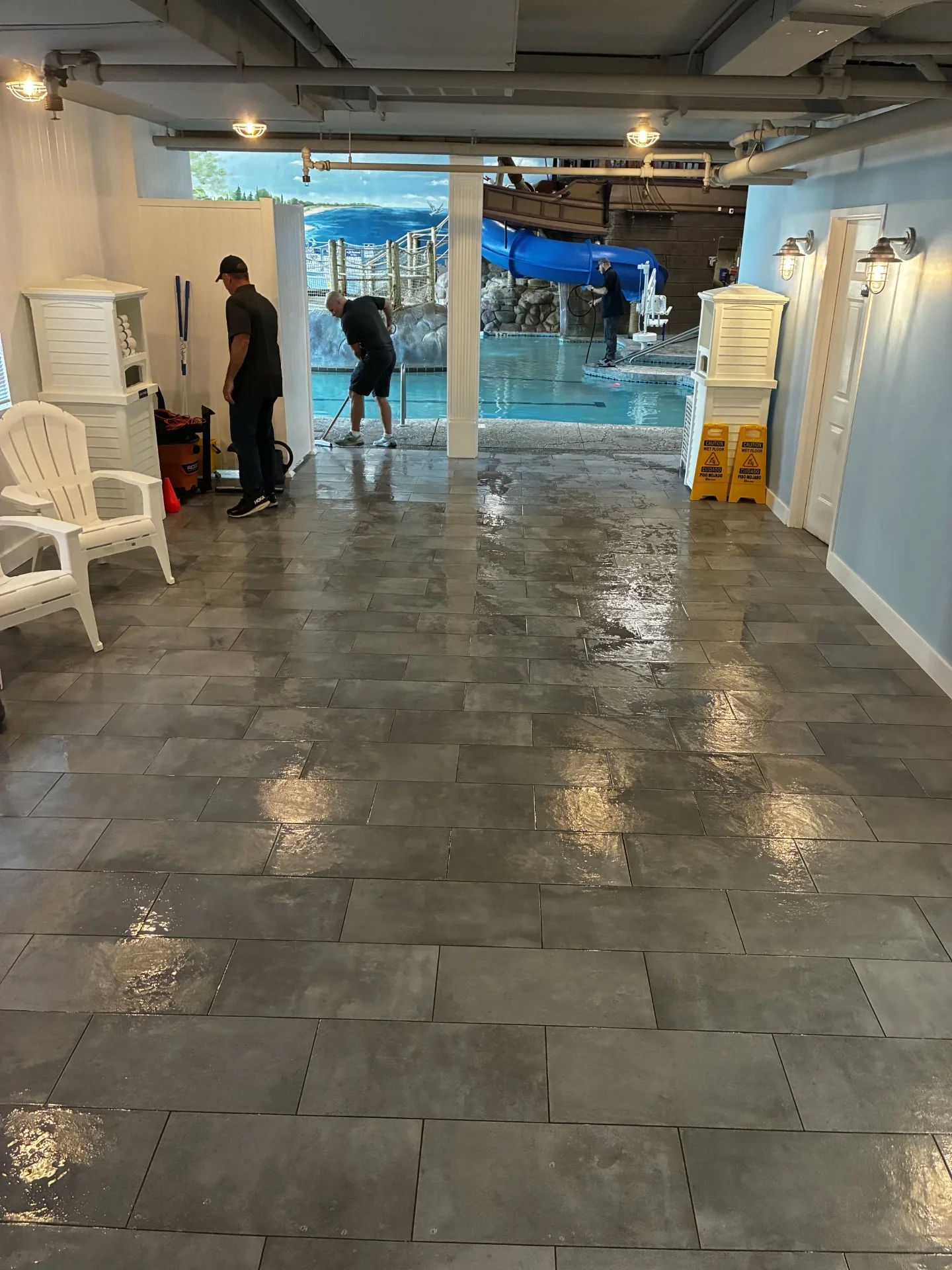 Gray epoxy-coated pool deck floor with slip-resistant finish and tile pattern layout