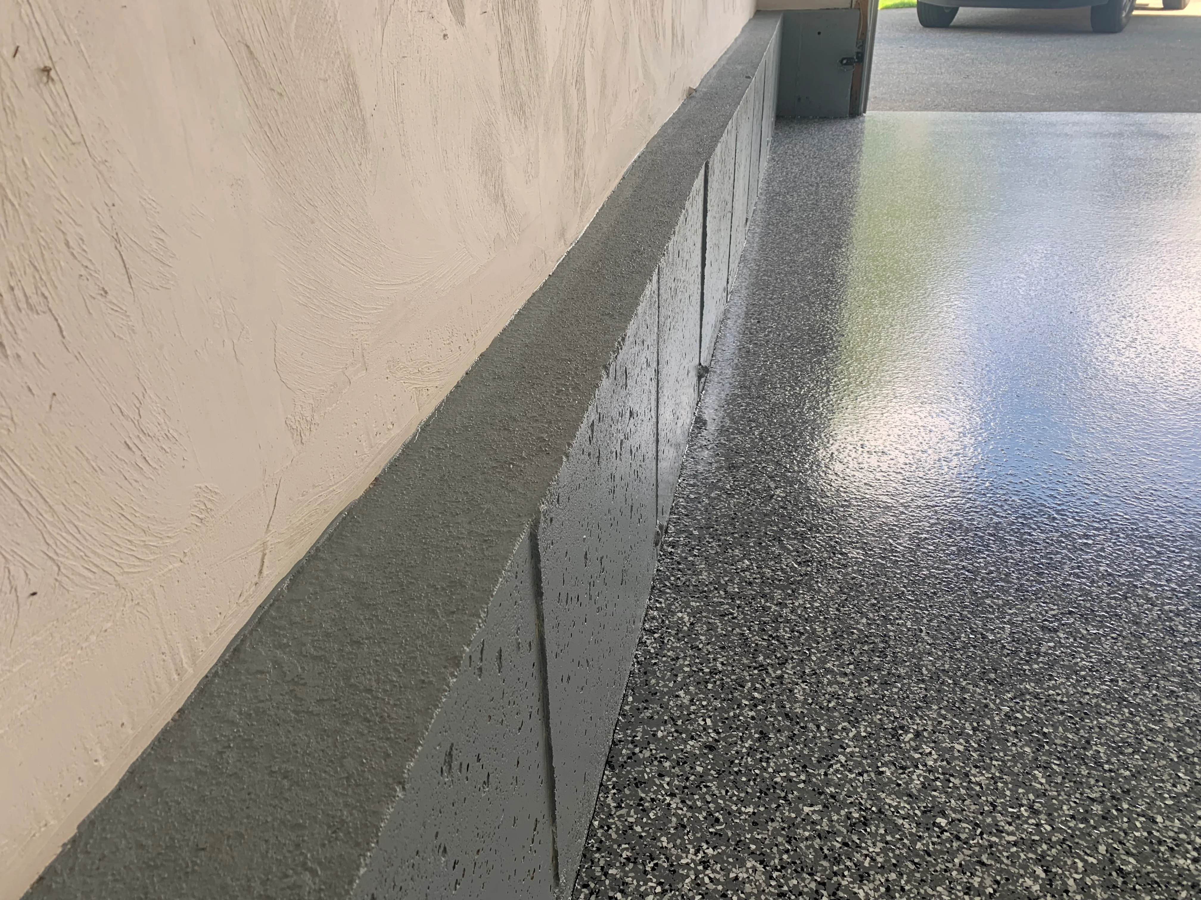 Epoxy flooring with aggregate finish and concrete curb edge detail
